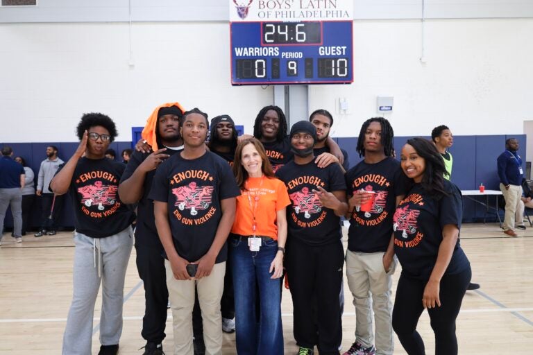 Sophia Collins posing on the basketball court with students.