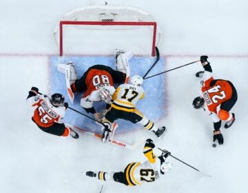 Pittsburgh Penguins' Bryan Rust (17) collides with Philadelphia Flyers' Dan Vladar (80) during the third period of Game 3 in the first round of the NHL Stanley Cup hockey playoffs Wednesday, April 22, 2026, in Philadelphia.
