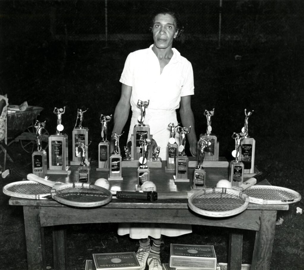 Ora Mae Washington poses behind her tennis awards