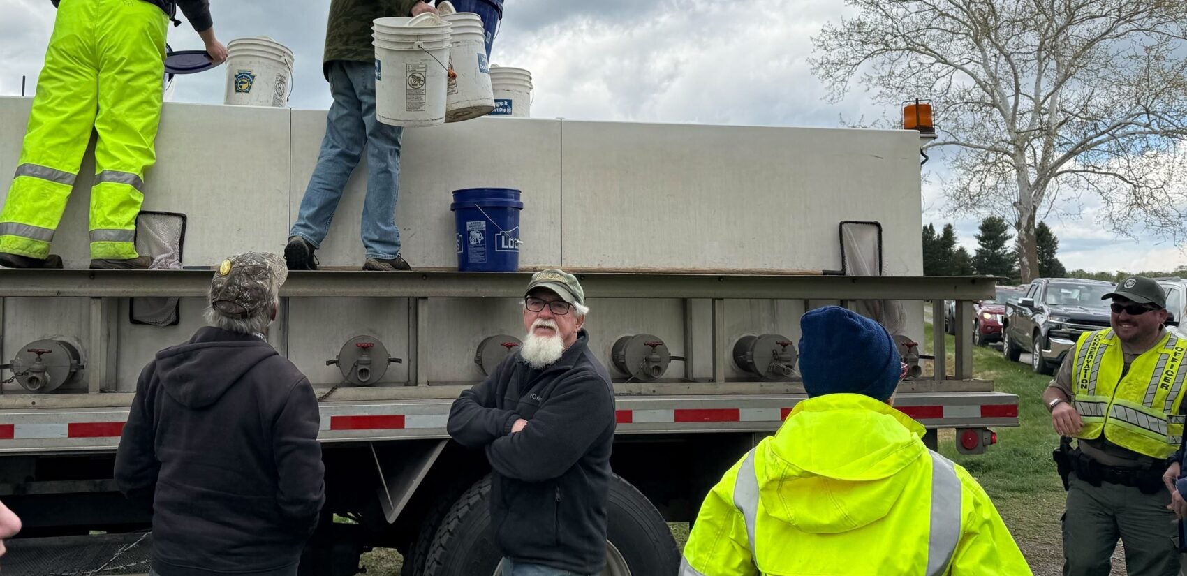 A white truck carrying a couple dozen wriggling trout pulls up near a stream in the White Clay watershed