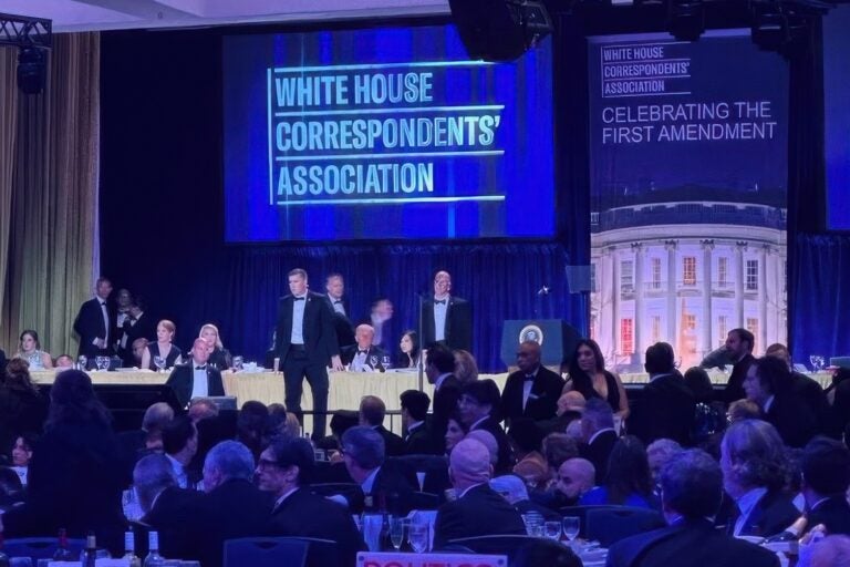 U.S. Secret Service agents surround President Donald Trump as he is taken from the stage after a shooting incident outside the ballroom during the White House Correspondents Dinner