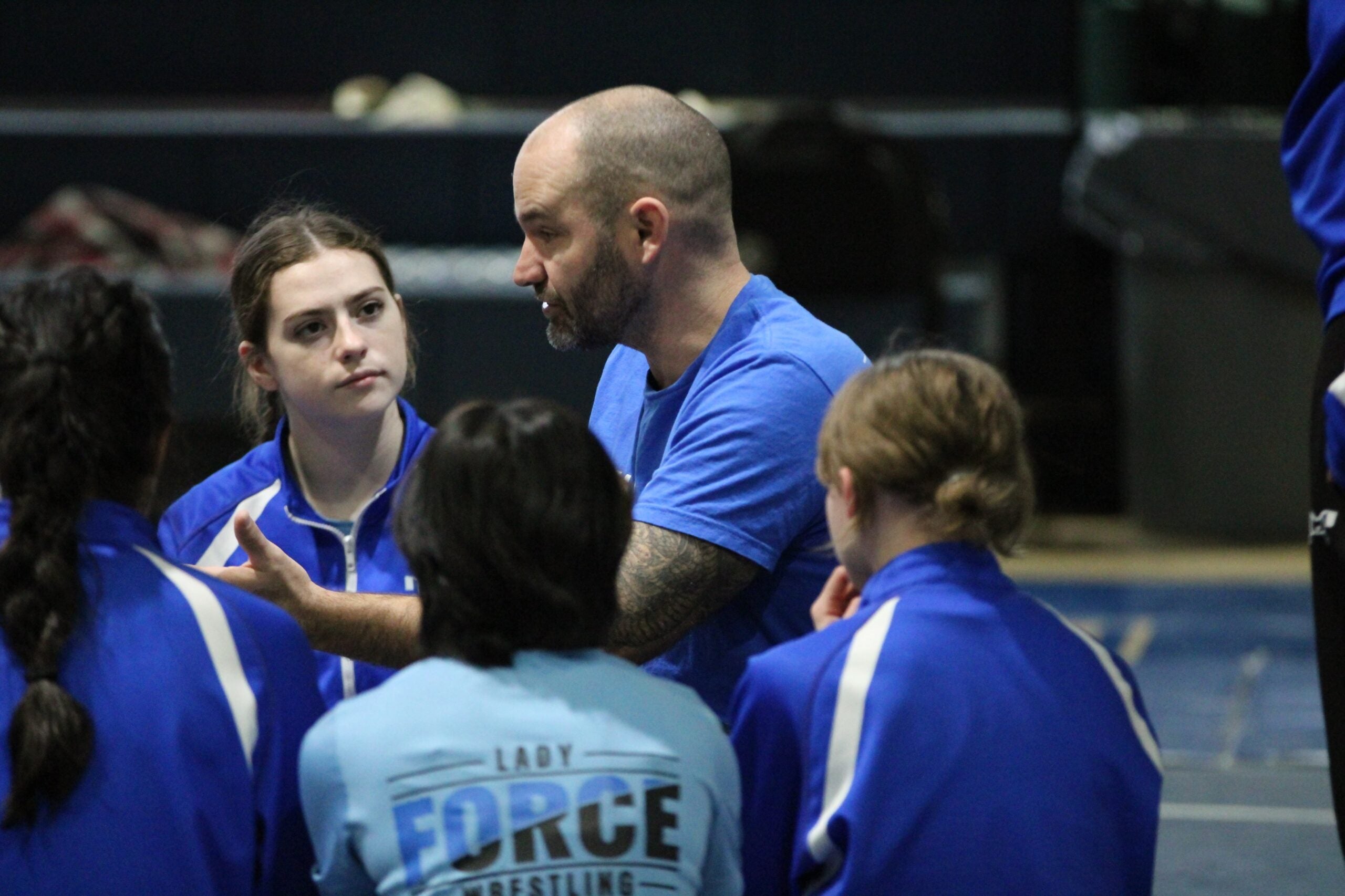 Coach Daniel Boone instructs some of the girls wrestlers at Charter School of Wilmington