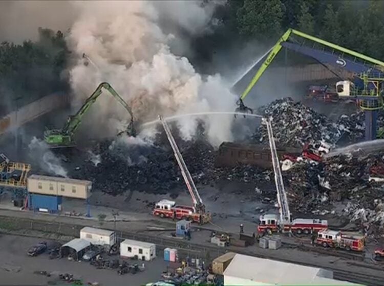 Firefighters work to put out scrap metal fire