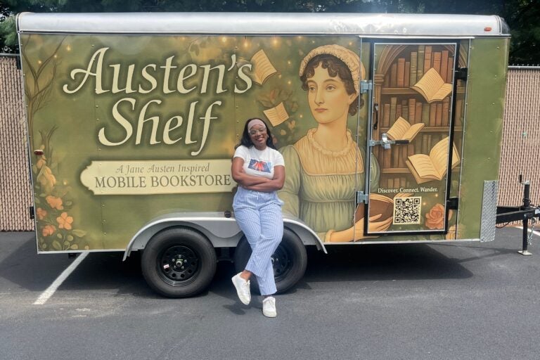 Charity Herndon smiles in front of the Austen's Shelf book trailer