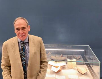 Selby Kiffer posing for a photo in front of a display case.