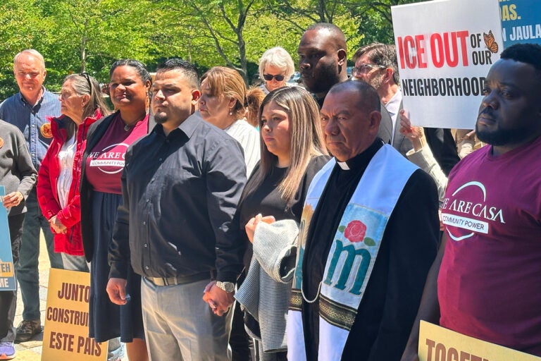 Kilmar Abrego Garcia and his wife, center, hold hands as people rally in support of him at a news conference outside federal court