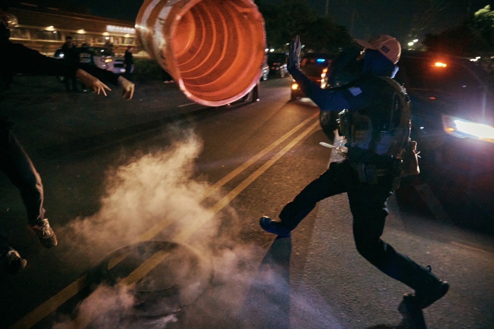 A protester throws a traffic cone to an ICE agent outside the Delaney Hall detention center during a protest on Wednesday, May 27, 2026, in Newark, N.J.