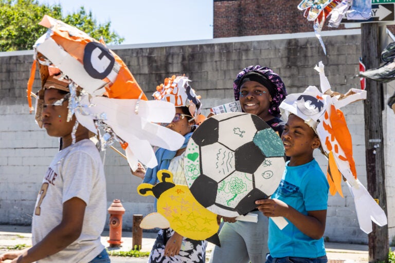 School children have a parade with their large puppets and signs.