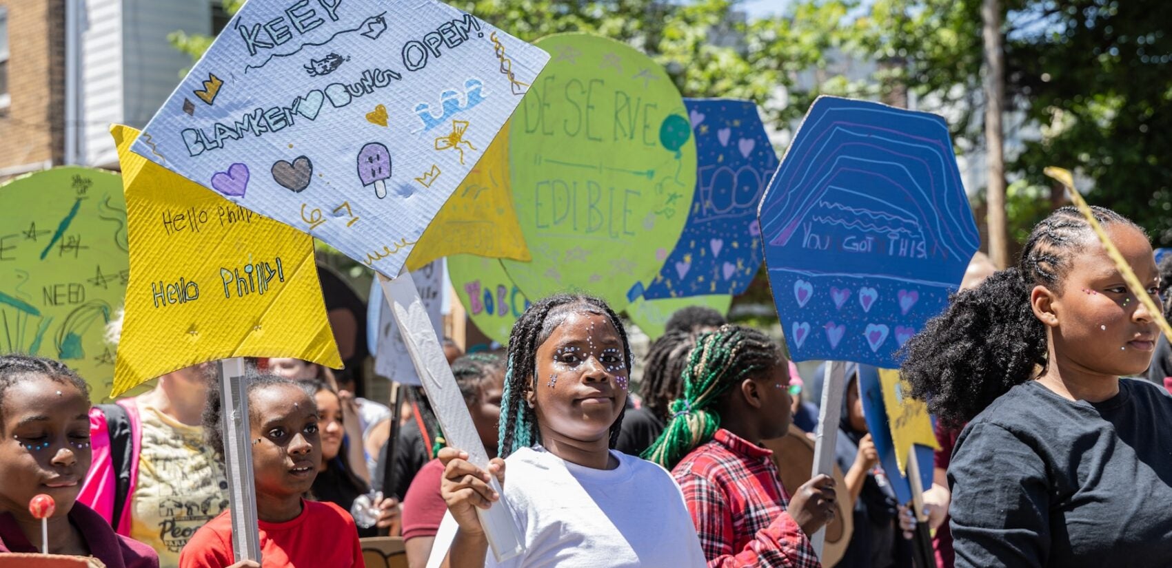 School children have a parade with their large puppets and signs.