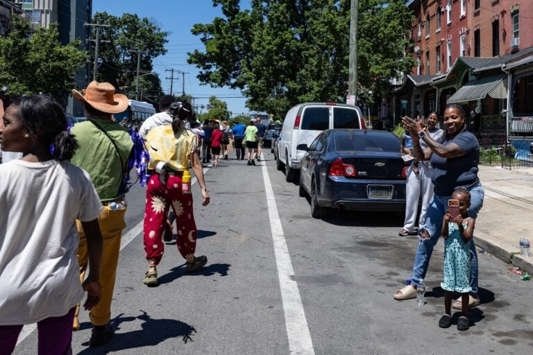 School children have a parade with their large puppets and signs.