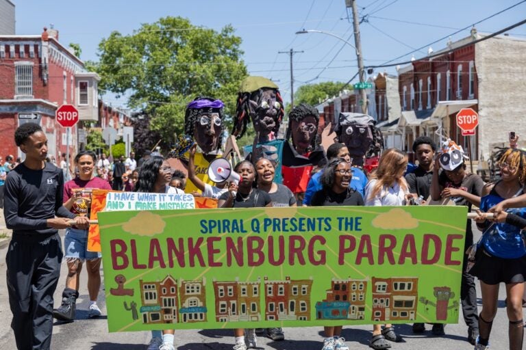 School children have a parade with their large puppets and signs.