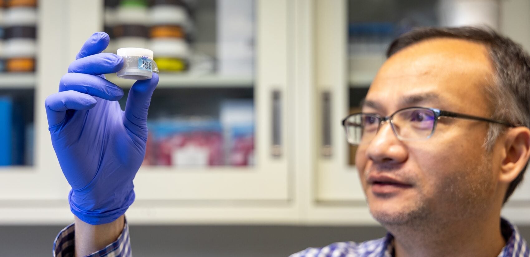 Kabindra Shakya holding up a sample in a small jar.