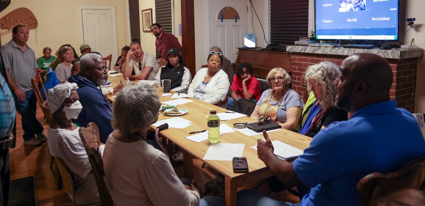 Many people sitting around a table listening to Arthur Barclay as he speaks