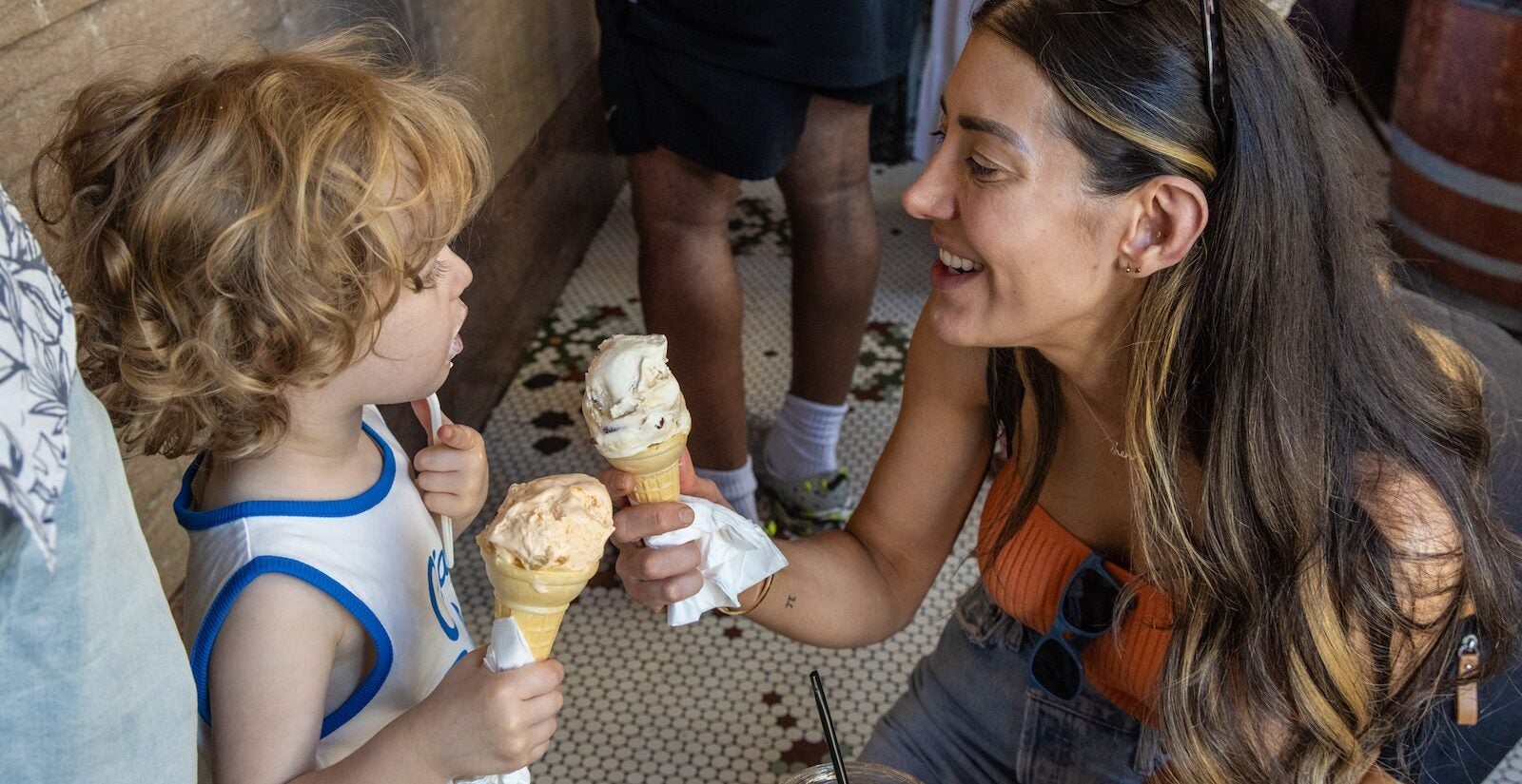 Lisa Theis and 3-year-old Henry hold up ice cream cones at Franklin Fountain in Old City, Philadelphia, amid Independence Day celebrations.