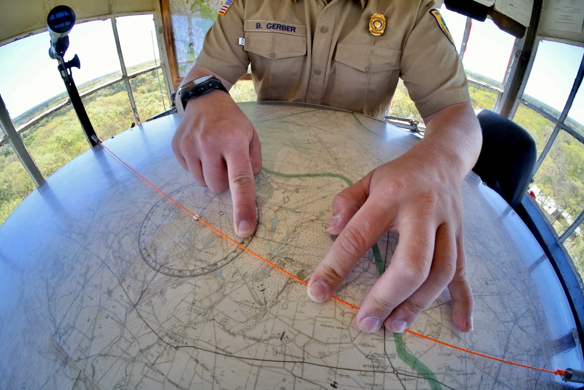 Brian Gerber pointing to a section on a map in the Medford Fire Tower.