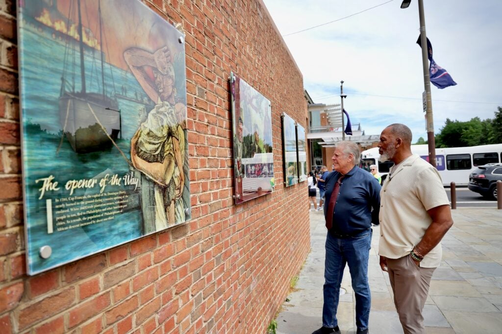 Kevin Douglass Green and Brian Evans pose for a photo at the President's House exhibit.