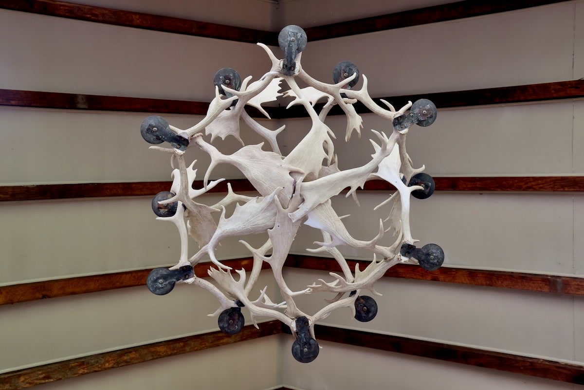 An antler chandelier hangs from the ceiling of the granary at Brinton's Mill. (Emma Lee/WHYY)