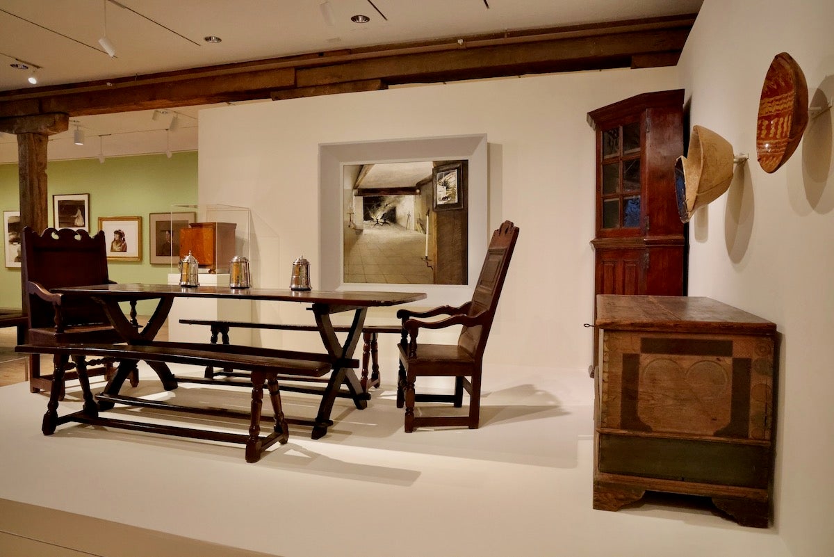 Visitors to ''By Design: The Worlds of Betsy James Wyeth'' at Brandywine Museum of Art, enter the exhibition through a re-creation of the Wyeth family dining room at Brinton's Mill. The dining room, the mill and the grounds around it were all carefully curated by Betsy Wyeth and in turn, painted by her husband, Andrew Wyeth. (Emma Lee/WHYY)