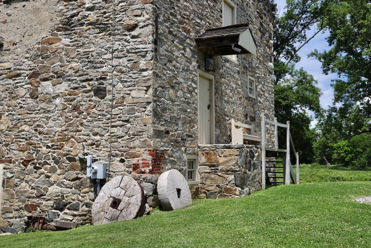 Mill stones lean against the corner of Brinton's Mill