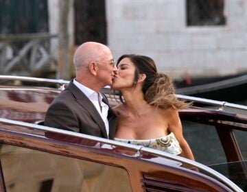 Jeff Bezos, center left, and Lauren Sanchez, center right, kiss as they leave a hotel for their pre wedding reception, in Venice, Italy, Thursday, June 26, 2025. (AP Photo/Luca Bruno)