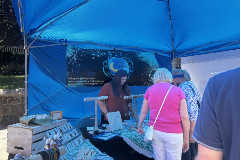 CUstomers inside a tent looking at various products for sale.