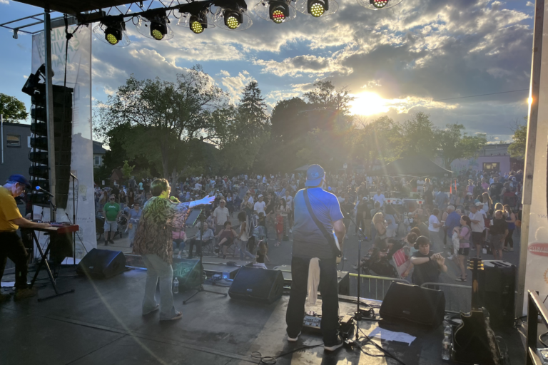 A view of UC3 from behind the band as they perform on stage at the festival.