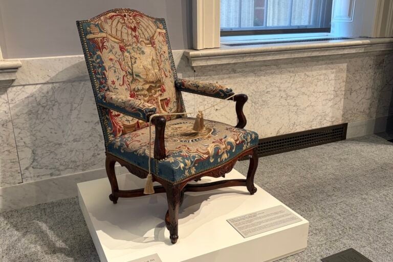 A historic chair with intricate patterns on the fabric.