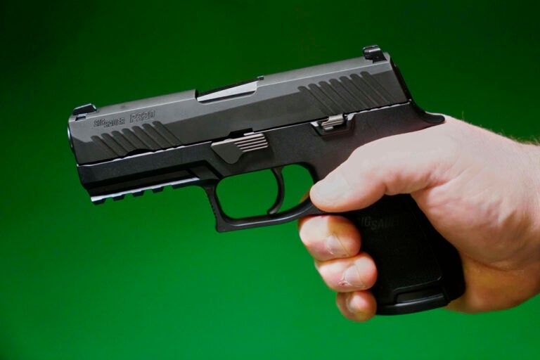 A Sig Sauer P320 handgun is held by a Maine gun shop owner, Tuesday, June 17, 2025. (AP Photo/Robert F. Bukaty)