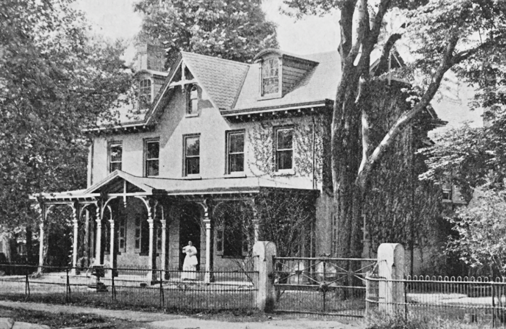 An archival photo of the Leibert House, with people standing on the front porch.