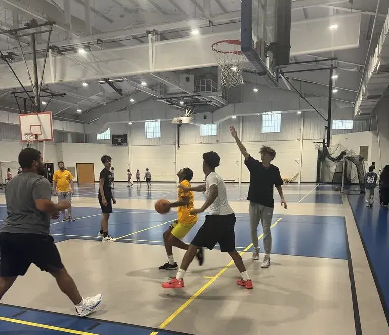 Kids playing basketball in a large gym