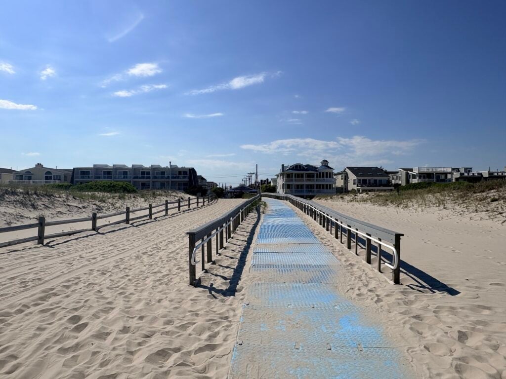 A path on the beach with mats on it.