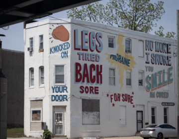 walnut-hill-love-language-mural-bp-2026-06-09 A white building has large colorful phrases painted all over it as part of a mural.