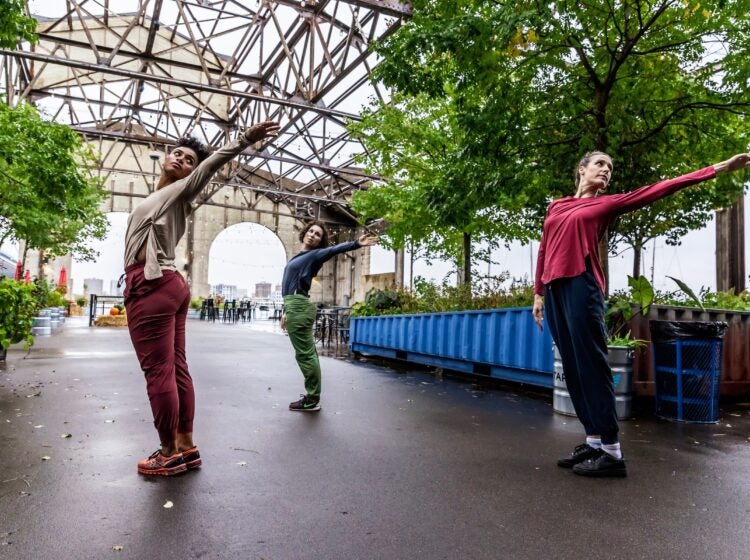Three dancers perform on the pier