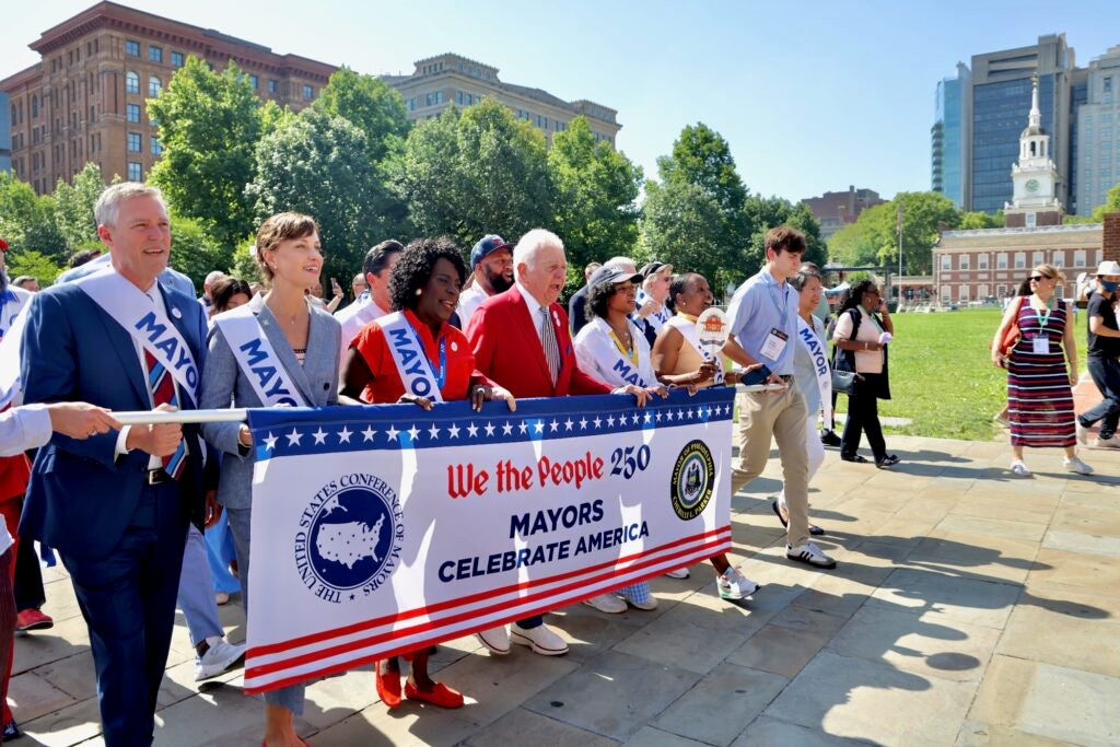 Members of the U.S. Conference of Mayors march through the city's historic district