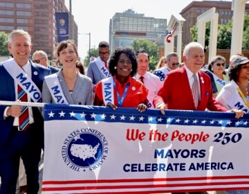 Members of the U.S. Conference of Mayors march through the city's historic district