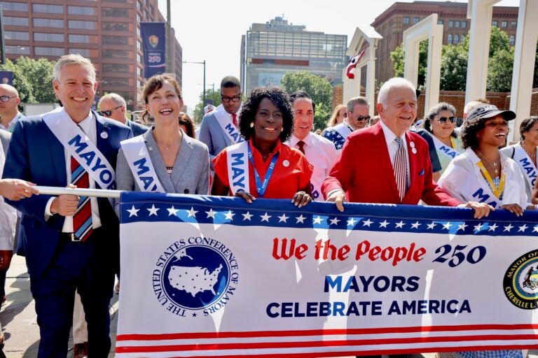 Members of the U.S. Conference of Mayors march through the city's historic district