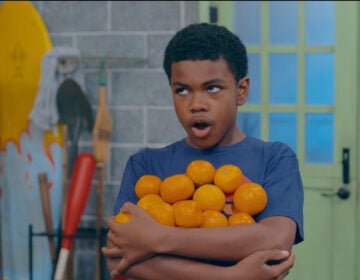 Good Neighbor Club cast member holding oranges