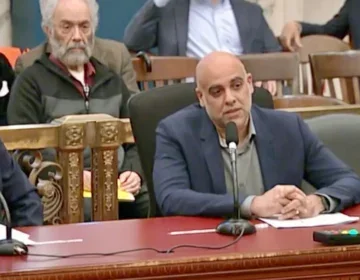 Jigar-Mehta-City-Council-March-2026 Jigar Mehta sitting at a desk speaking into. a mcf[