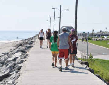 North Wildwood Seawall – Photo Credit Greater Wildwoods Tourism Improvement and Development Authority A family walks along the boardwalk next to the beach.