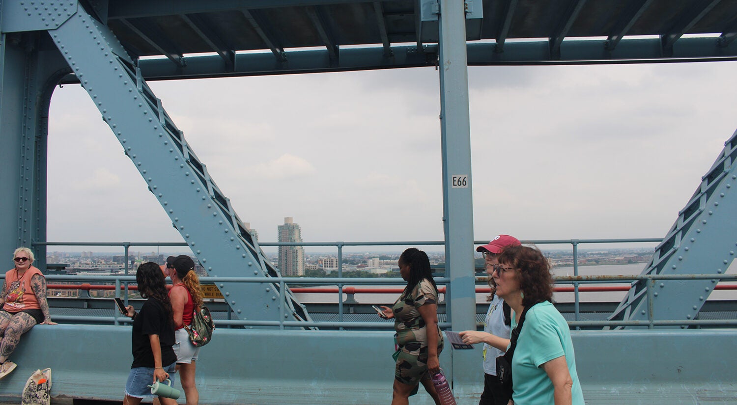 People walk on the Ben Franklin Bridge