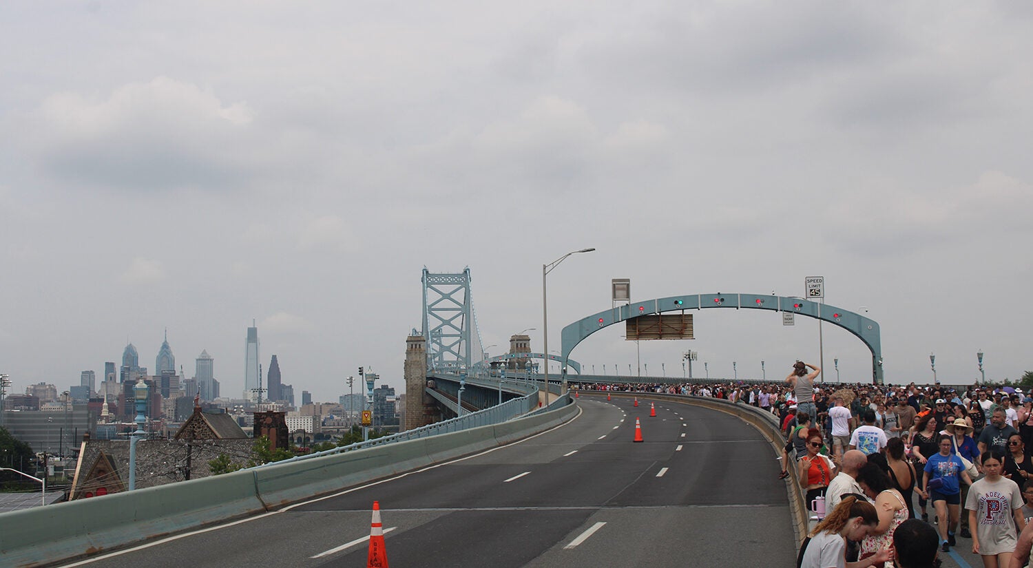 People line up on the side of the Ben Franklin Bridge