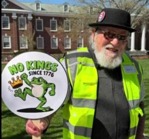 Bud Glassner holds a sign reading NO KINGS SINCE 1776