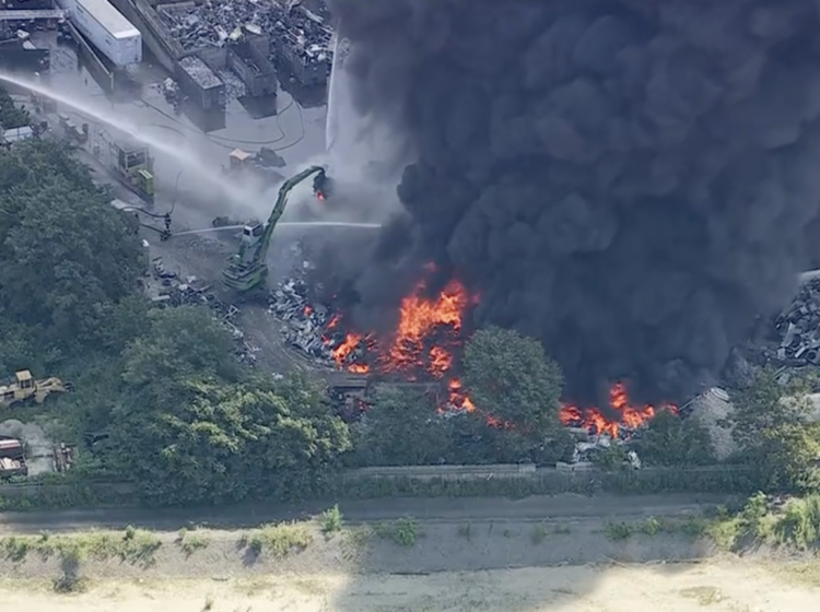 firefighters spraying water onto the large fire.