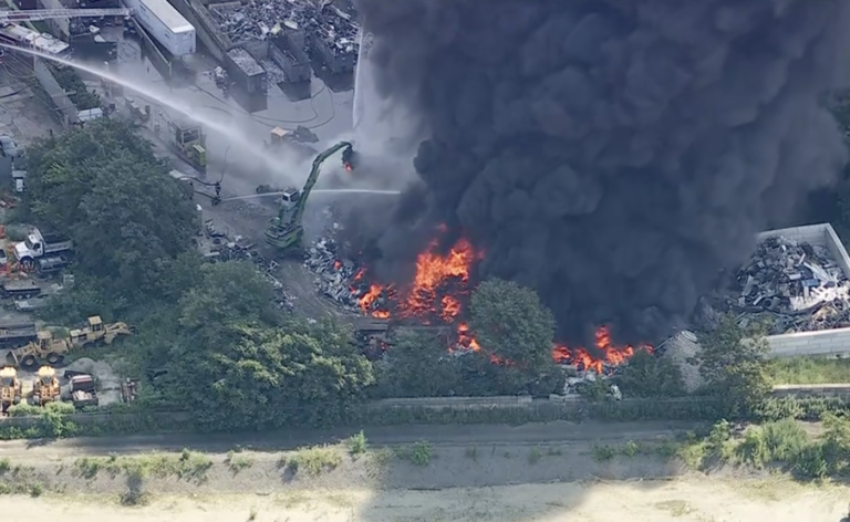 firefighters spraying water onto the large fire.