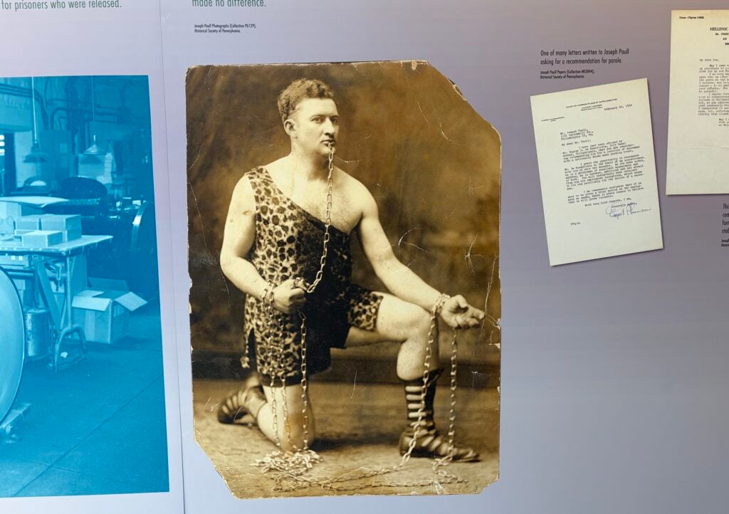 Hanging on the wall in the exhibit is an archival photo of Joseph Paull posing in his circus strongman attire.