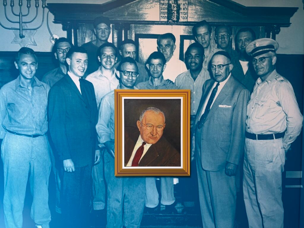 a large mural on the wall of people imprisoned, presenting a framed portrait to Joseph Paull.