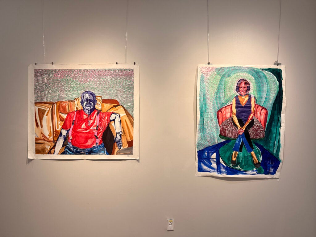 Two paintings hang in an exhibit