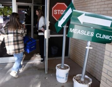 FILE - Health department staff members enter the Andrews County Health Department measles clinic