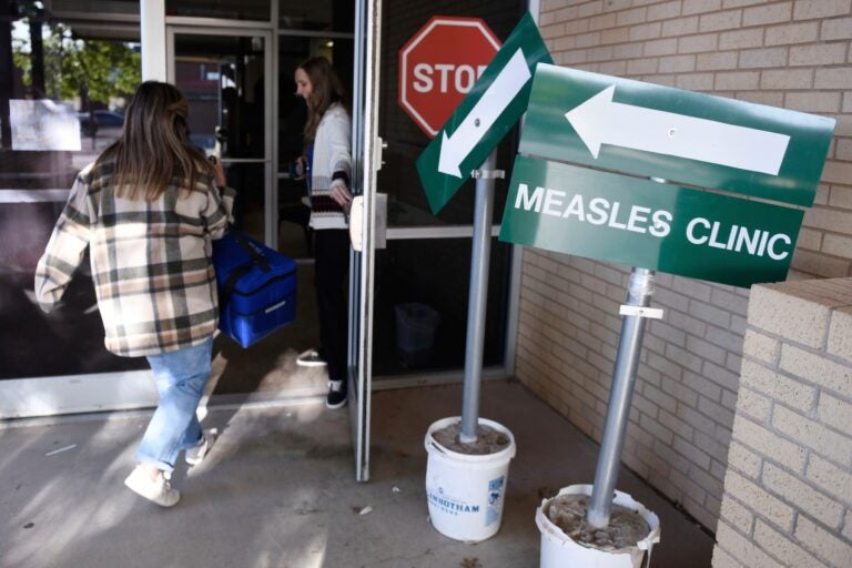 FILE - Health department staff members enter the Andrews County Health Department measles clinic