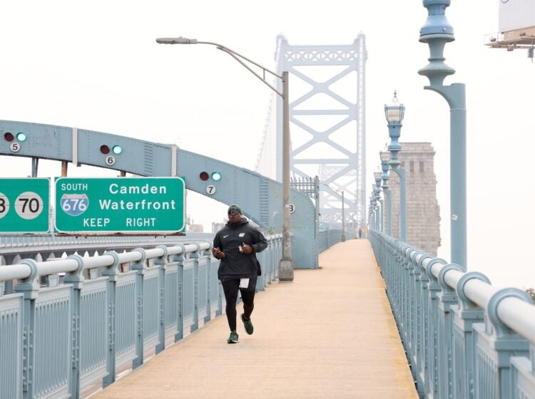 Tarir Satterfield-Rowe of Camden jogs across a smoke shrouded Ben Franklin Bridge